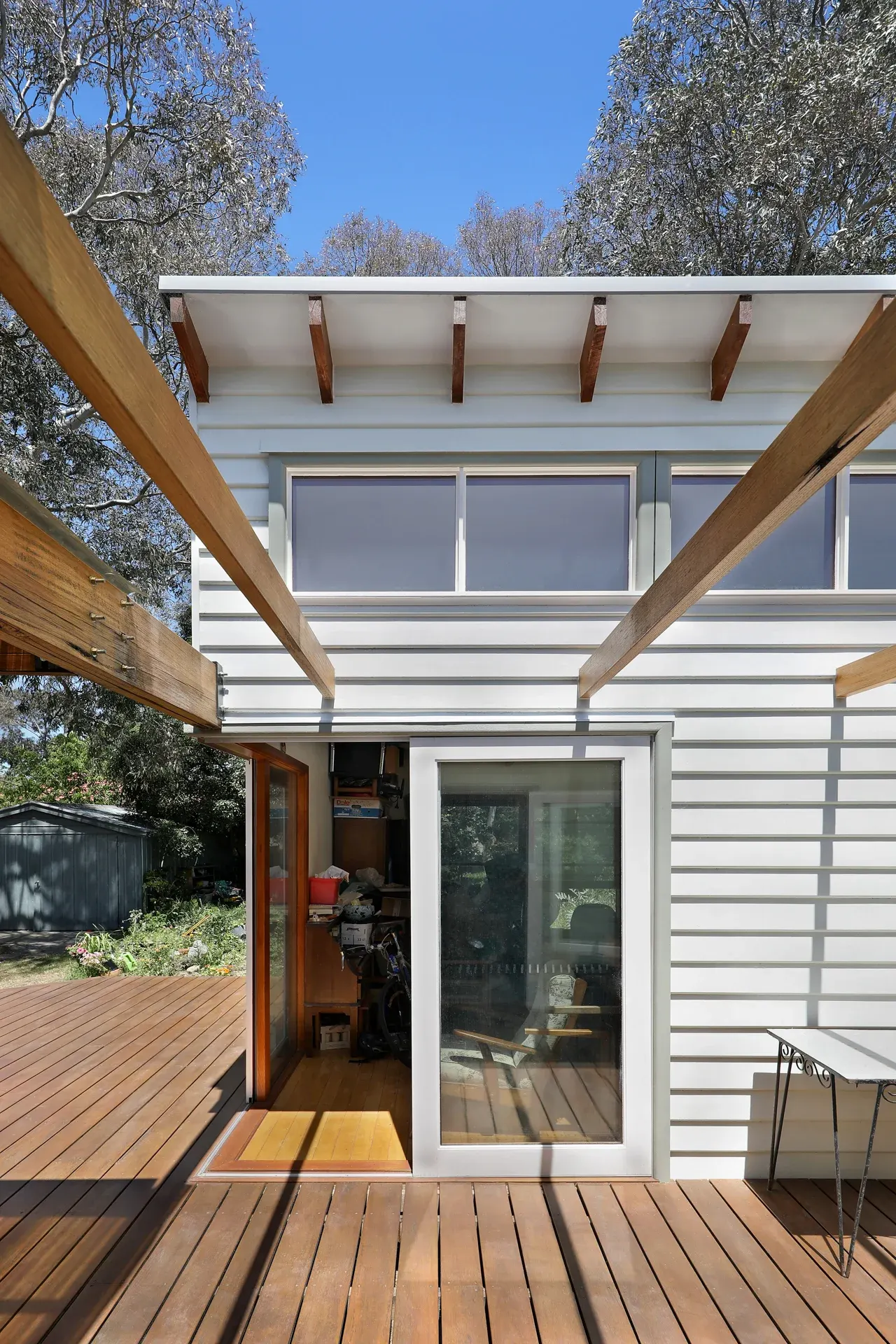 Timber deck with large sliding doors connecting to pergola and garden, Joynt Street Macleod — Eco Building Design