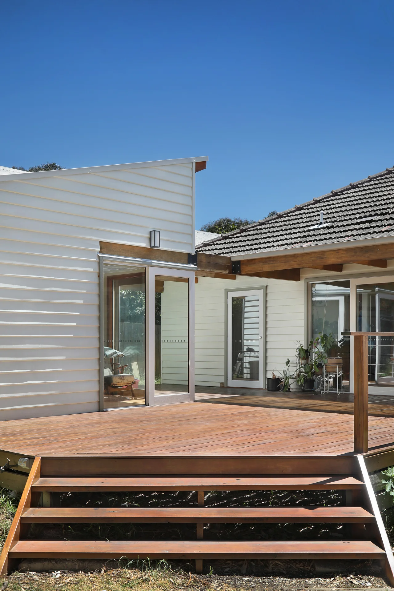 Timber deck and steps of the modern rear addition under a deep blue sky, Joynt Street Macleod