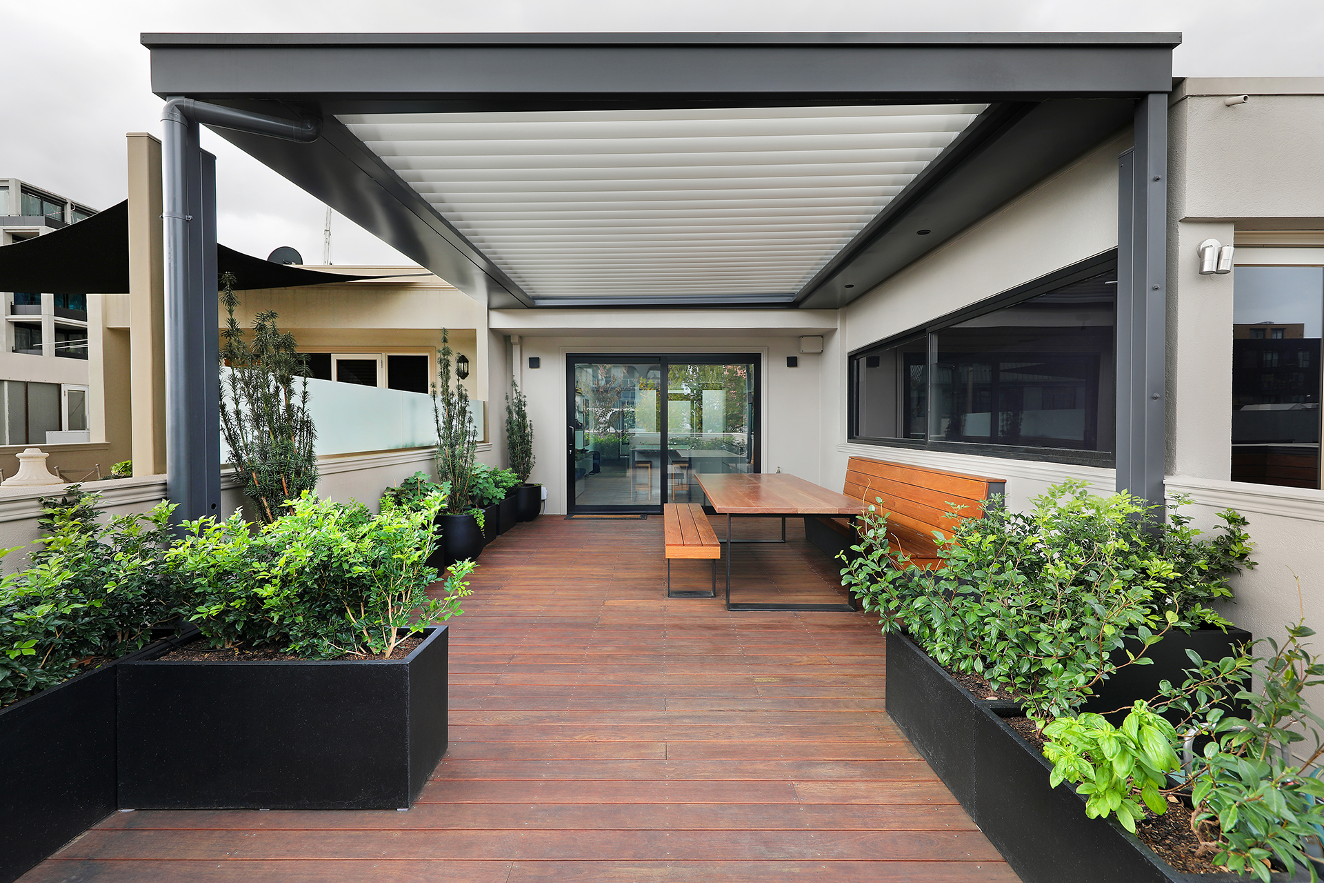 Rooftop deck with operable louvres providing passive shading in Fitzroy